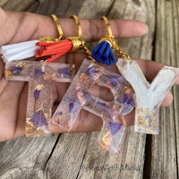 a person is holding a keychain with the words try and tassels