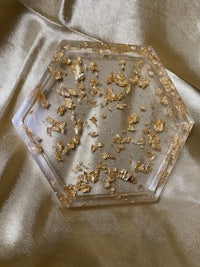 a clear hexagonal tray with gold flakes on it