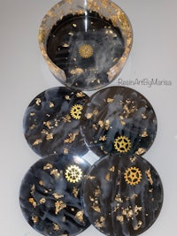 a set of black and gold coasters on a table