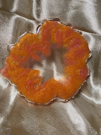 a piece of glass with an orange flower on it