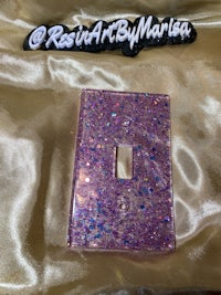 a pink and purple glitter light switch cover