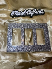 a silver glitter switch plate with the word rasi art maria on it