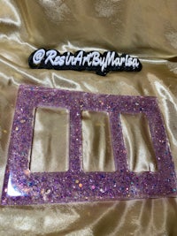 a purple glitter light switch cover with the word resa art