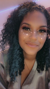 a woman with blue curly hair is posing for a selfie