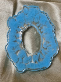 a blue glass ring on a satin sheet