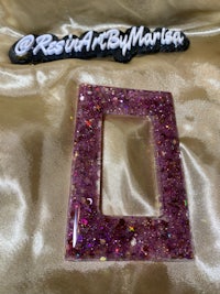 a purple glittered frame on a satin sheet