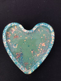 a heart shaped tray with a lot of splatters on it